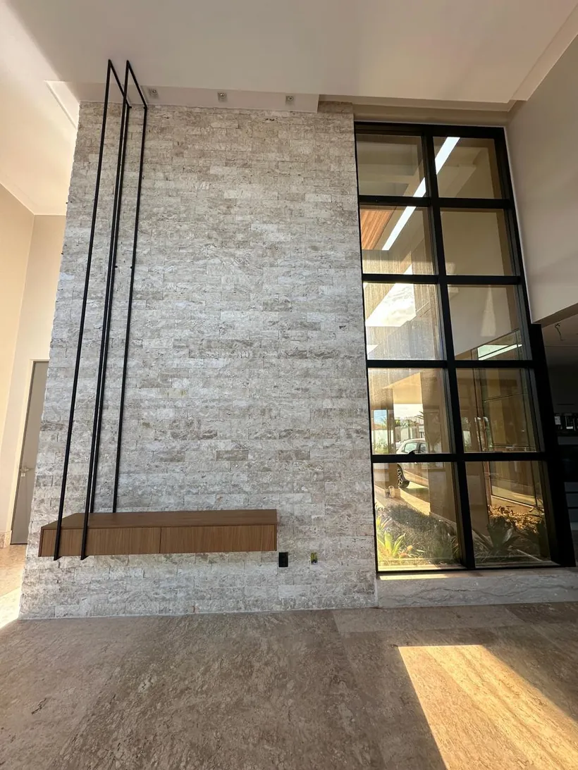 Hall em pedra natural com escada suspensa