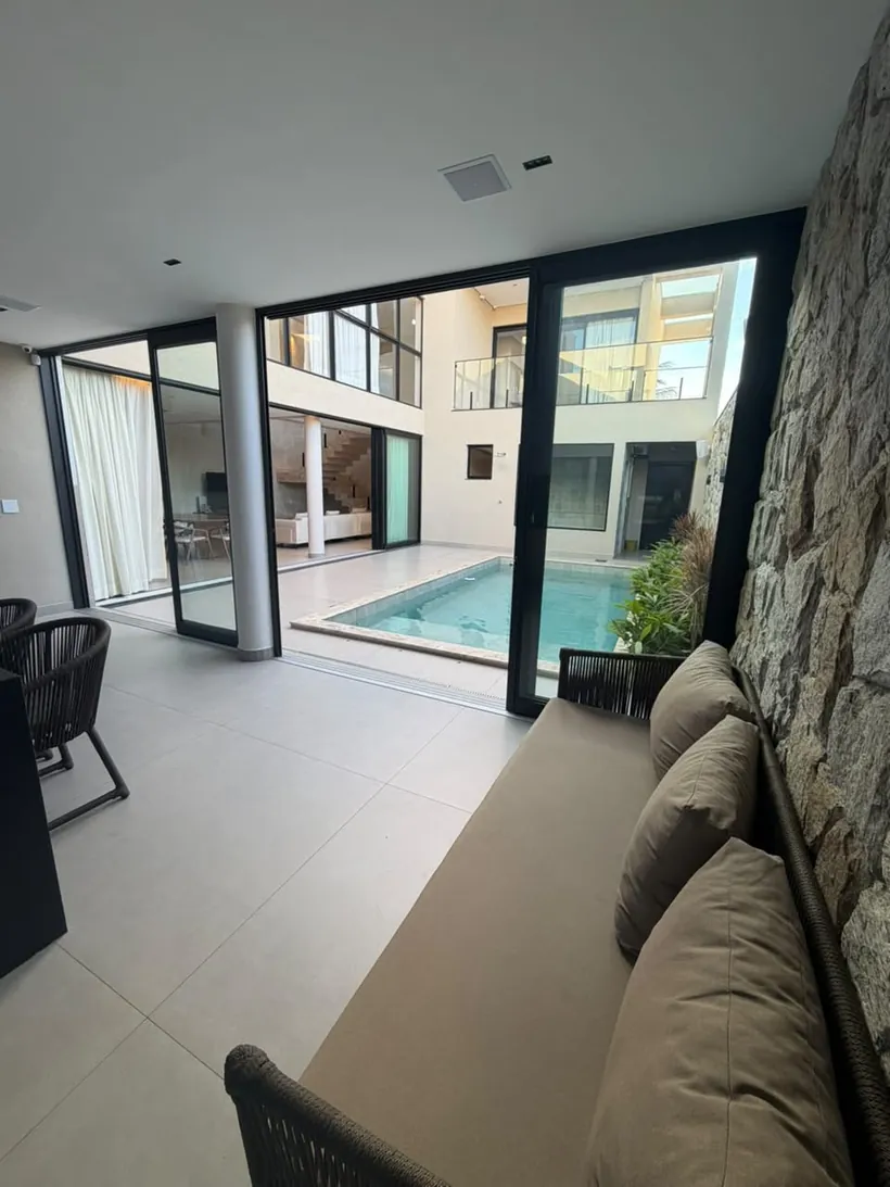 Pátio com piscina e parede em pedra natural nas Arniqueiras